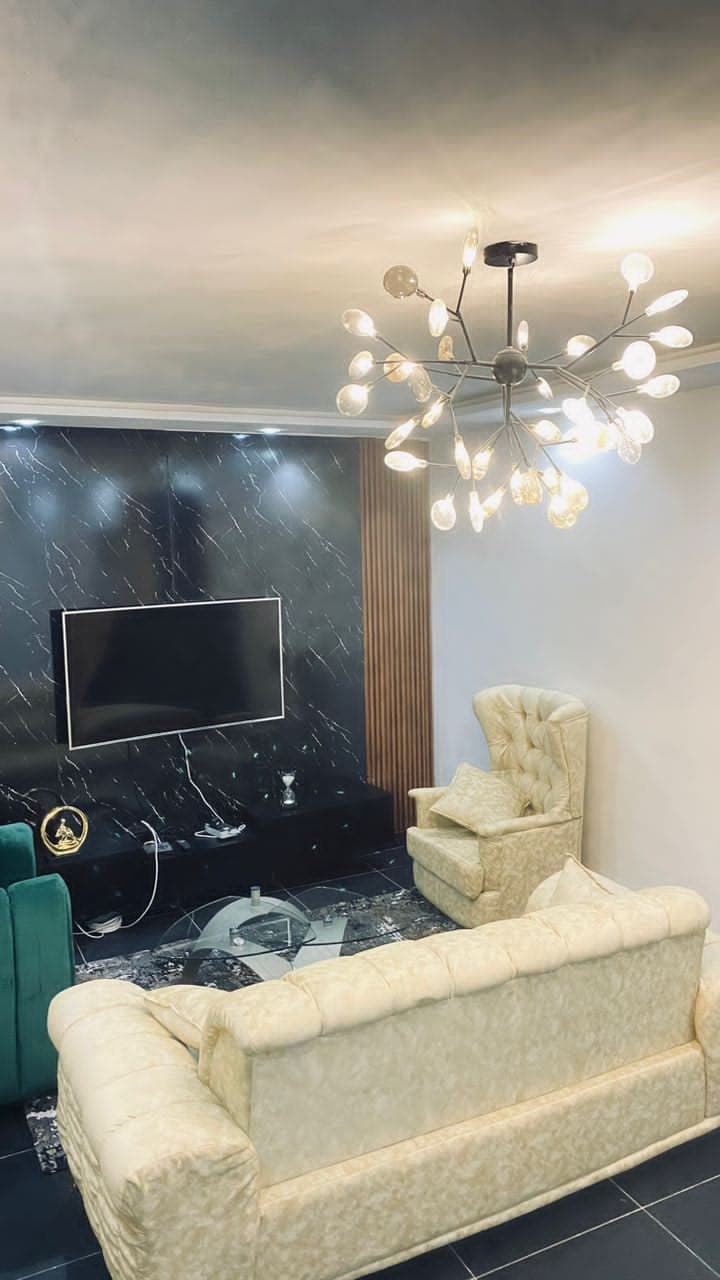 Mur TV en marbre noir et fauteuil capitonné
