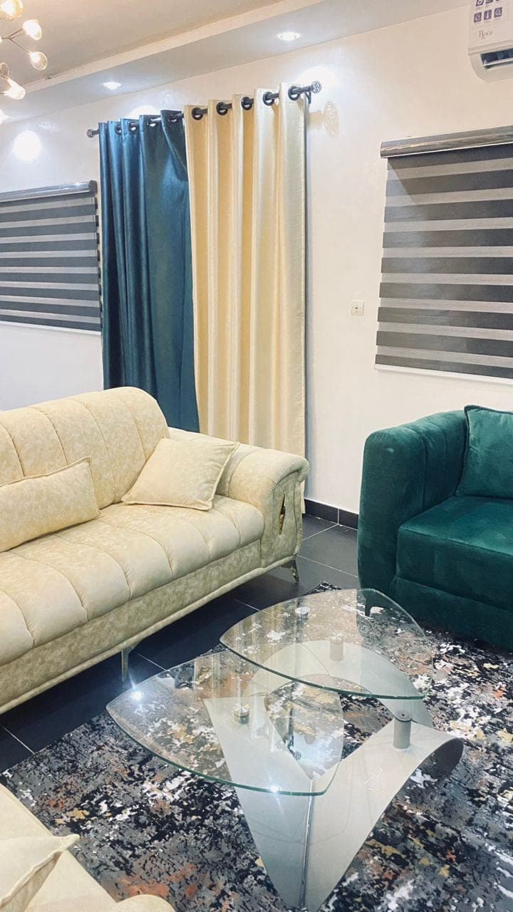 Salon au canapé crème et fauteuil vert