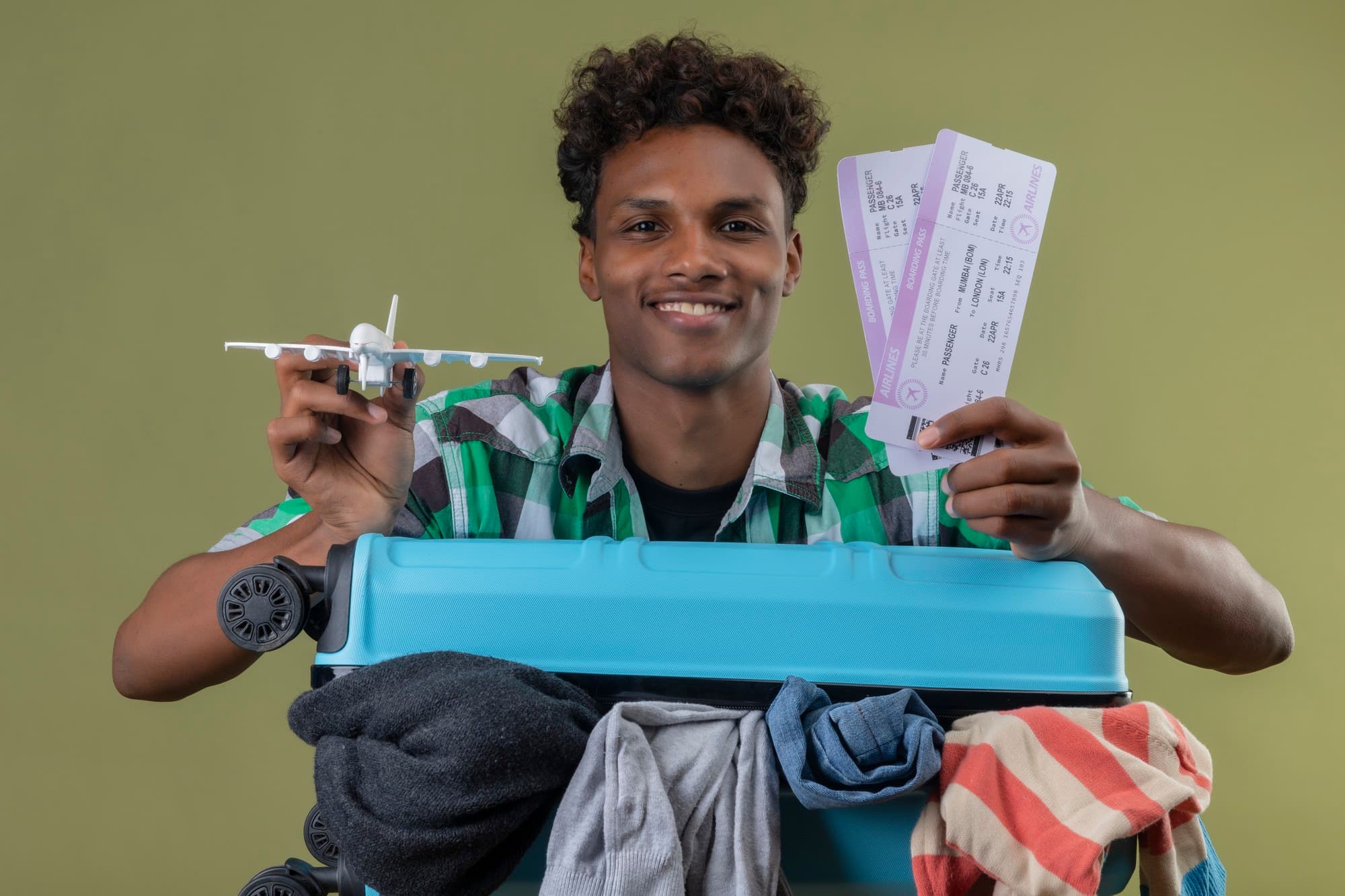 Voyageur souriant tenant ses billets d'avion et sa valise